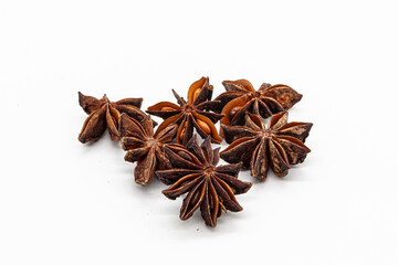 Close-up of a handful of dried, brown star anise stars. Isolated on a clean white background, this spice is perfect for culinary projects, menus, winter recipes, and holiday advertising.