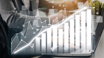 A professional businessman works on a laptop, analyzing growth trends represented by a bar graph and line chart in a modern office, highlighting strategic insights. Copula