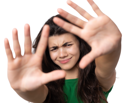 Portrait of a serious young woman showing stop gesture with her palm over white background
