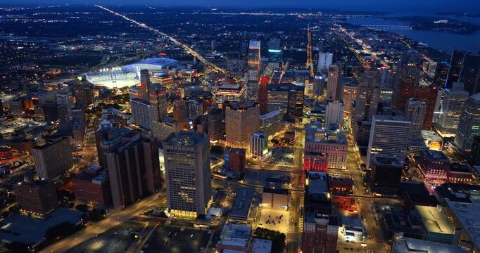 Luminous streets of Detroit go from the downtown to uptown. Panorama of the city from drone in the evening.