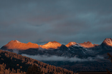 Golden Sunrise Over the Swiss Alps with Autumn Forest Below