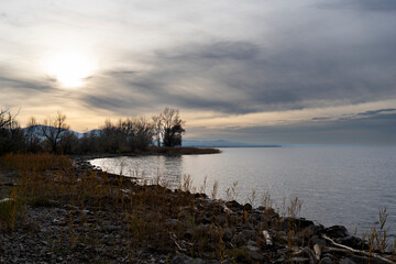 sunset in clouds over a bay in Lake Constance Bodensee on the border near Rohrspitz in Höchst, Vorarlberg, Austria