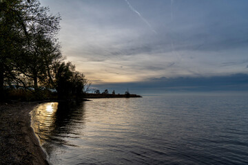 sunset in clouds over a bay in Lake Constance Bodensee on the border near Rohrspitz in Höchst, Vorarlberg, Austria
