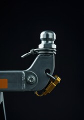 A heavy-duty metal trailer hitch mechanism locked and secured, showing industrial strength and reliable connection, linked, fixed, logistics