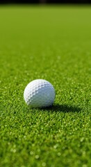 A pristine white golf ball sits motionless upon perfectly manicured, emerald green fairway turf, illuminated by bright daylight, field, park, game