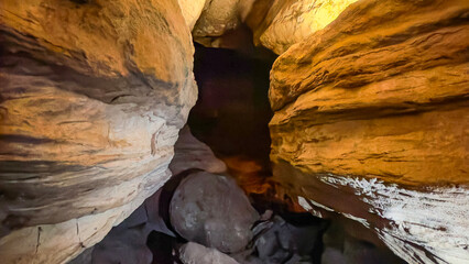 Natural Cave Passage with Rock Formations and Warm Illumination