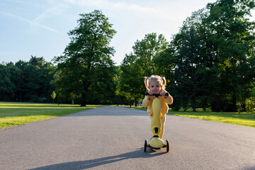 Girl on scooter. Riding child outdoor fun. Sunshine road freedom lifestyle.