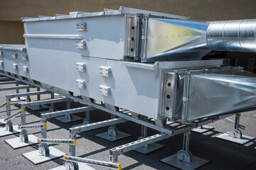 A ventilation unit rests on steel supports on the building's roof.