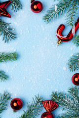 Christmas composition with red holiday ornaments and green fir branches covered with snow on a...