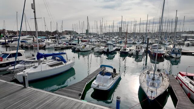 Pleasure boats and yachts moored in Gosport Marina. Pan right