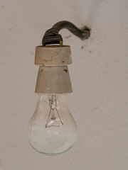 A non-illuminated filament bulb in a white socket with a white background.
