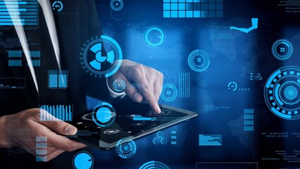 A businessman interacts with a tablet displaying a modern digital interface featuring analytics, graphs, and data visualization, illustrating technology integration in business. Xenic