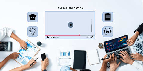 Aerial view of diverse hands engaged in online education activities, featuring technology tools, charts, and multimedia learning materials for effective digital training. Trope