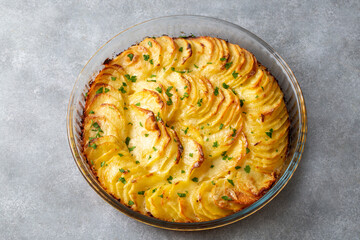 Potato gratin - graten (baked potatoes with cream and cheese) with rosemary and forks (Turkish name; Kremali patates)