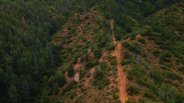Person rising by the stairs in the green mountains of Manitou Incline . Exploring the Manitou Springs, Colorado, USA.