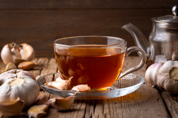 Cup of healthy garlic tea on table