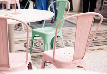 pastel pink and green colored chairs at the table
