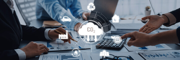 A diverse business team engages in a collaborative discussion on effective strategies to lower carbon emissions, emphasizing innovative solutions and sustainable practices. Trope