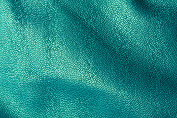 Green genuine leather as a background macro photo.