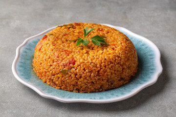 Traditional turkish bulgur pilaf with tomato sause in plate (Turkish name; meyhane pilavi)