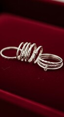 Elegant silver rings collection on a rich red background, jewelry fashion.