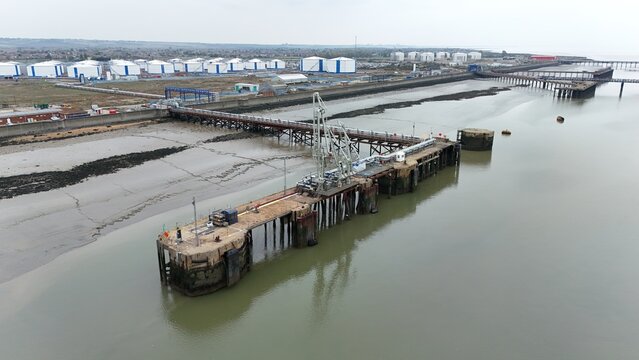 Aerial drone view of gas terminals and storage silos fuel docks for loading and unloading LPG from ships on the River Thames, Canvey Island, UK