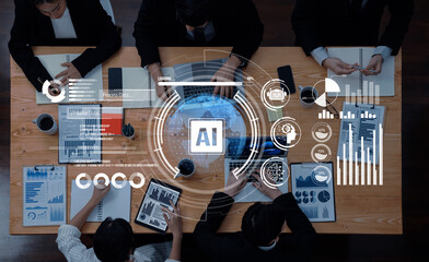 A diverse business team engaged in data analysis using artificial intelligence, featuring charts and graphs displayed digitally above a collaborative workspace. Trope