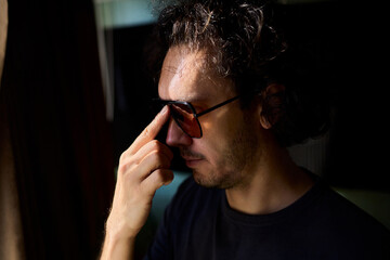 Nighttime artistic portrait, Creative director by window scene, Moody cinematic image of nighttime scene, Reflective lenses capturing introspective moments at night