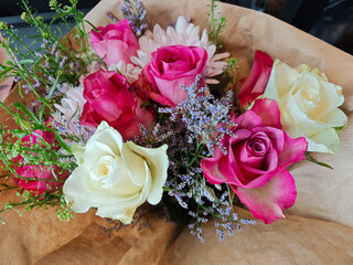Vibrant bouquet of assorted flowers featuring pink and white roses arranged with greenery and filler flowers