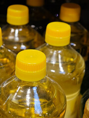 Close-up view of plastic bottles filled with yellow liquid in a grocery store display at midday