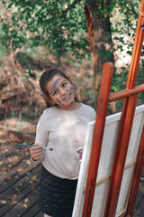 Obraz premium little girl painting in the forest