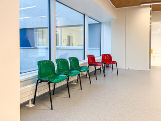 Modern hospital corridor featuring colorful chairs in a clean, spacious environment designed for comfort and rest, showcasing contemporary design elements and inviting ambiance