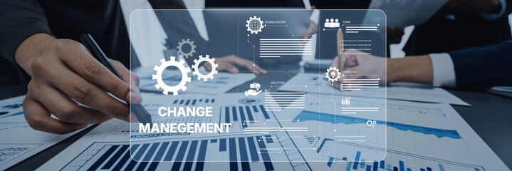 Business professionals collaborate on change management strategies, reviewing charts and data in a modern office. Focus on teamwork and innovative solutions. Trope