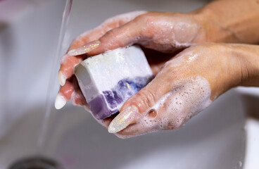 Fototapeta premium Woman thoroughly washing her hands with soap