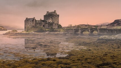 A foggy early Scottish morning at Eilean Donan Castle during lowtide in Dornie, UK