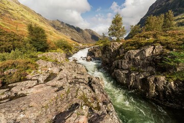 An autumn hike in Scotland along River Coe with view of Glencoe waterfall in Ballachulish, UK