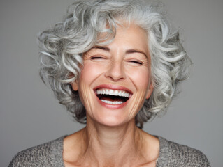 Gorgeous mid age beautiful elderly senior woman with grey hair laughing and smiling. Healthy face skin care beauty, skincare cosmetics, dental