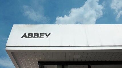 Historic Abbey word sign in bold letters on a classic stone building, viewed against a brilliant blue sky. Perfect for travel, history, and architectural themes
