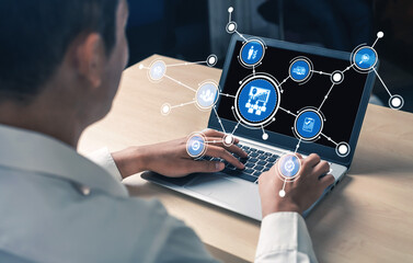 A business professional interacts with a laptop showcasing digital graphs and icons, symbolizing innovation in data analytics and modern technology in a workspace. Tessel