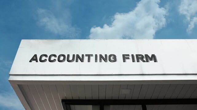 Prominent Accounting Firm sign displayed on a sleek commercial building, contrasted against a bright blue sky. Ideal for corporate finance, professional services, and wealth management themes