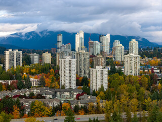 Fototapeta premium Autumn Cityscape Of Burnaby High Rise Apartments With Mountain Backdrop In Vancouver BC