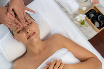 Fototapeta premium Panorama top view of woman enjoying relaxing anti-stress head massage and pampering facial beauty skin recreation leisure in dayspa modern light ambient at luxury resort or hotel spa salon. Quiescent