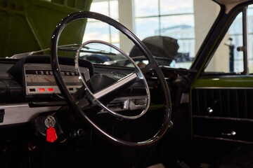 Obraz premium Closeup of a modern car steering wheel with control buttons for technology and convenience