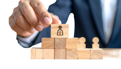 A hand places a person icon block atop a wooden pyramid, symbolizing hierarchy