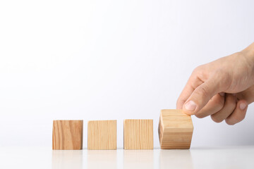Man with wooden cubes on white background, closeup. Space for text