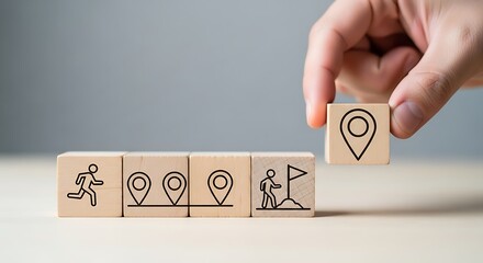 Hand placing a wooden block with a location pin icon, completing a path of progress and achievement