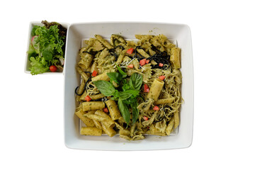 Delicious pasta with pesto and salad, a culinary delight. The meal is beautifully arranged, ready to be enjoyed