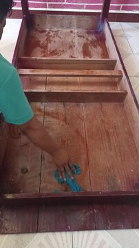 Hombre Pintando Parte Interior de Mesa de Madera