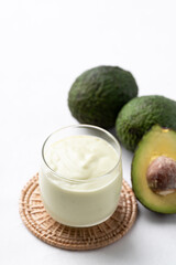Avocado smoothie with milk in glass and avocado fruit on white background, Healthy drink