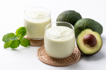 Avocado smoothie with milk in glass and avocado fruit on white background, Healthy drink